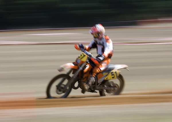 A motocross rider at full speed in a long distance cross country race