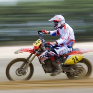 A motocross rider at full speed in a cross country event