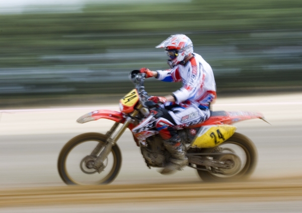 A motocross rider at full speed in a cross country event