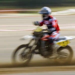 A motocross rider at full speed in a cross country event