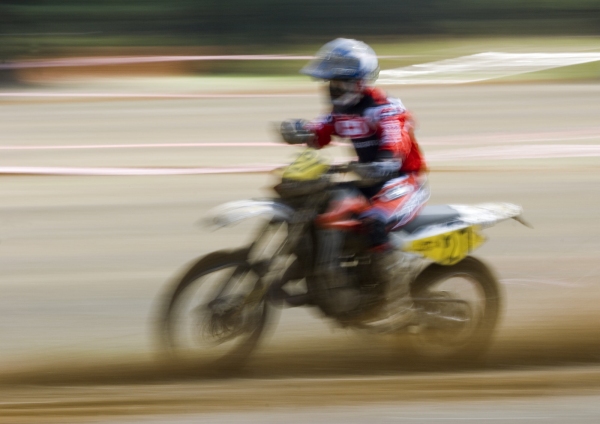 A motocross rider at full speed in a cross country event