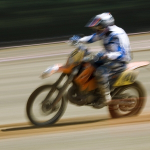 A motocross rider at full speed in a cross country race