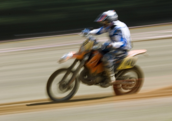 A motocross rider at full speed in a cross country race