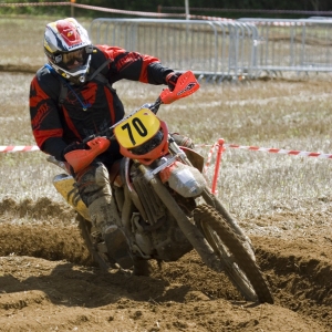 A motocross rider cornering at full speed in a long range race