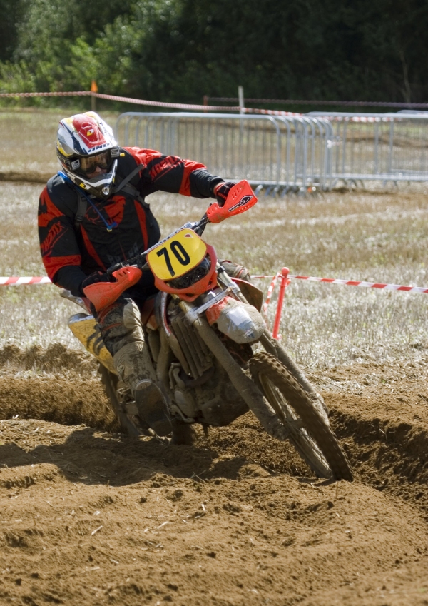 A motocross rider cornering at full speed in a long range race