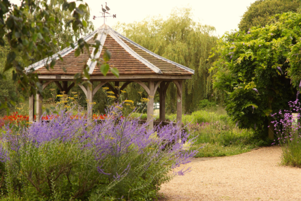 A pavilion in an English country garden in high summer