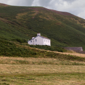 A white house set against a Welsh hillside on the Gower Peninsula