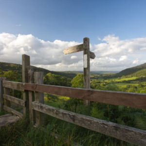 A view across the Brecon Beacons in South Wales with public footpath sign in the foreground